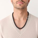 Black bead necklace on man from different angle