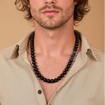 Large black bead necklace on man’s chest